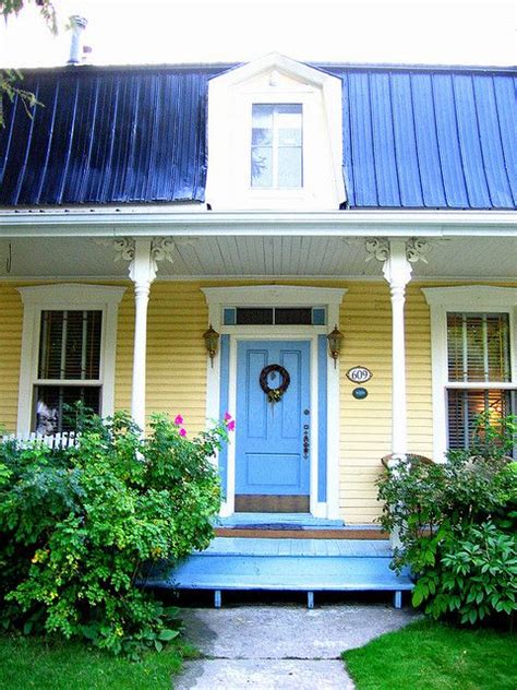 yellow house with blue metal roof|pictures of houses painted yellow.